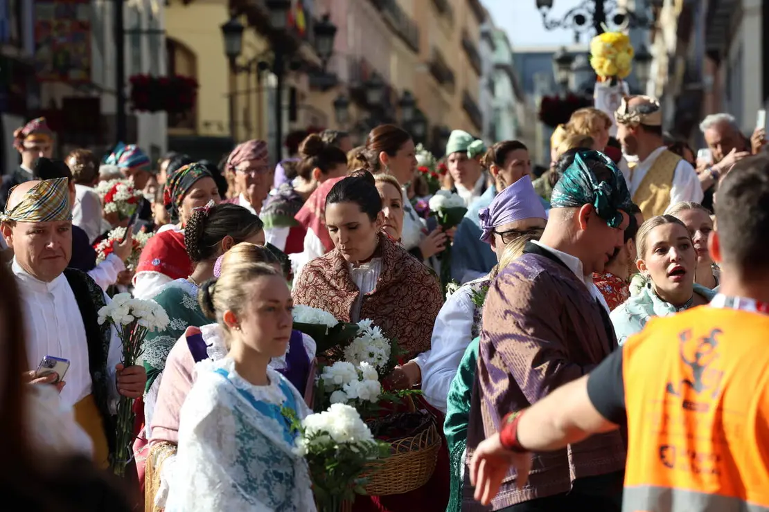 Imagen de los zaragozanos, con ramo en mano, yendo camino a dejar su ramo de flores a la Virgen del Pilar a primera hora de la ma&ntilde;ana. Fotograf&iacute;a: Fiestas del Pilar Oficial / Zaragoza Cultura.