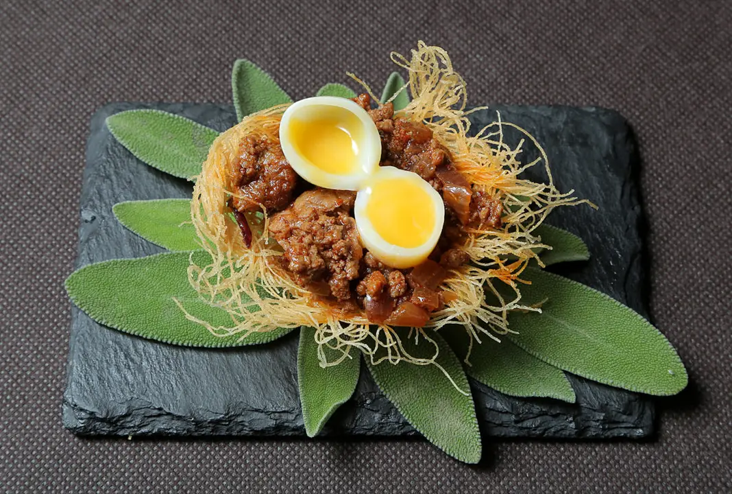 Un nido con ternasco y huevo, en Envero Gastro Wine / Caf&eacute; y Bares
