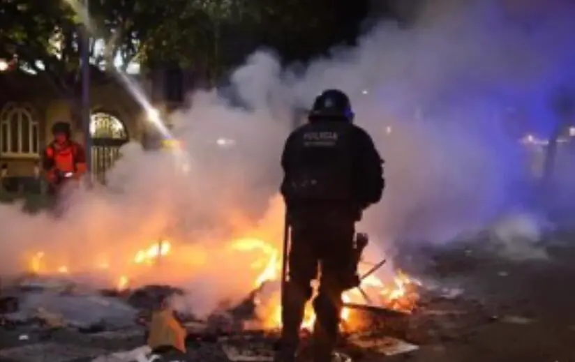 Imagen de un polic&iacute;a nacional aislado por el fuego durante las protestas en Barcelona /Europa Press