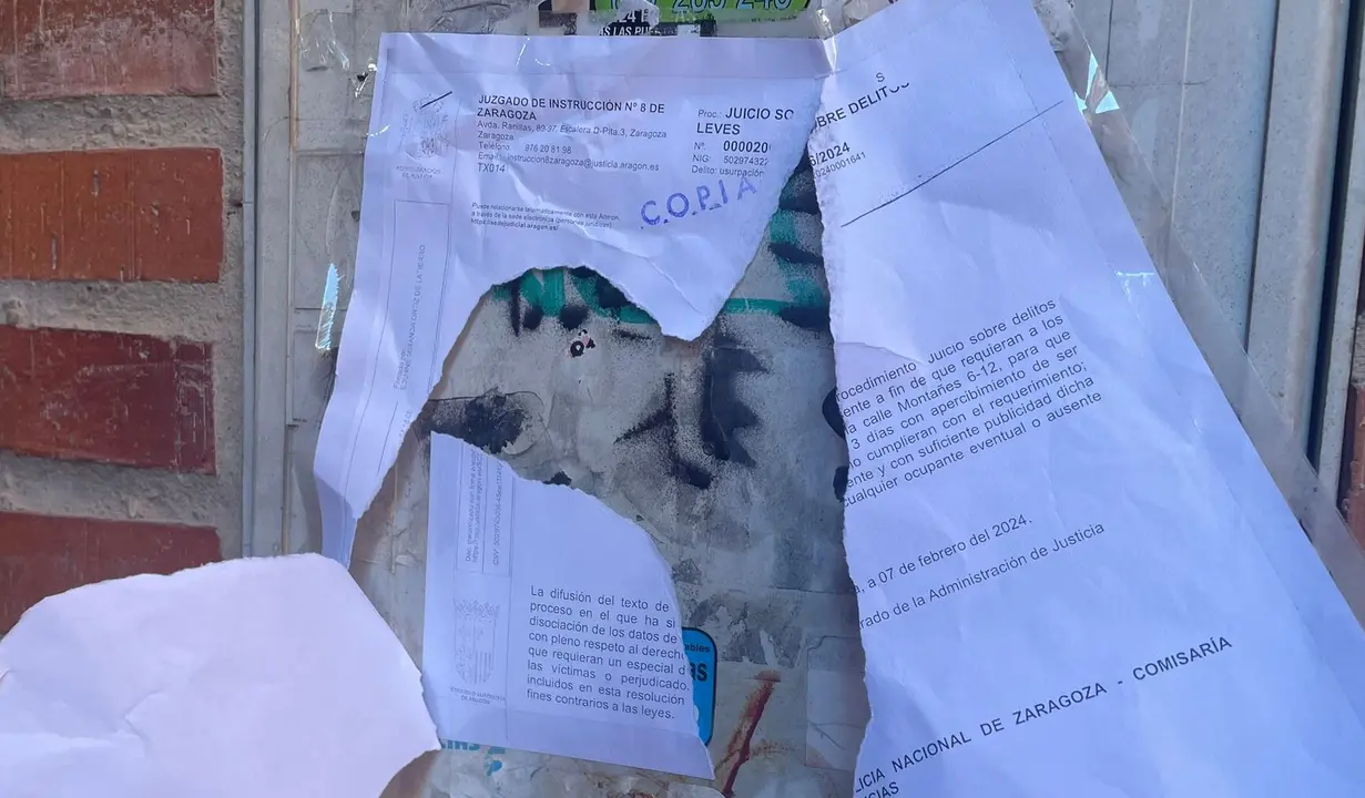 La orden del juzgado rota en la puerta del garaje de Delicias /H.A.