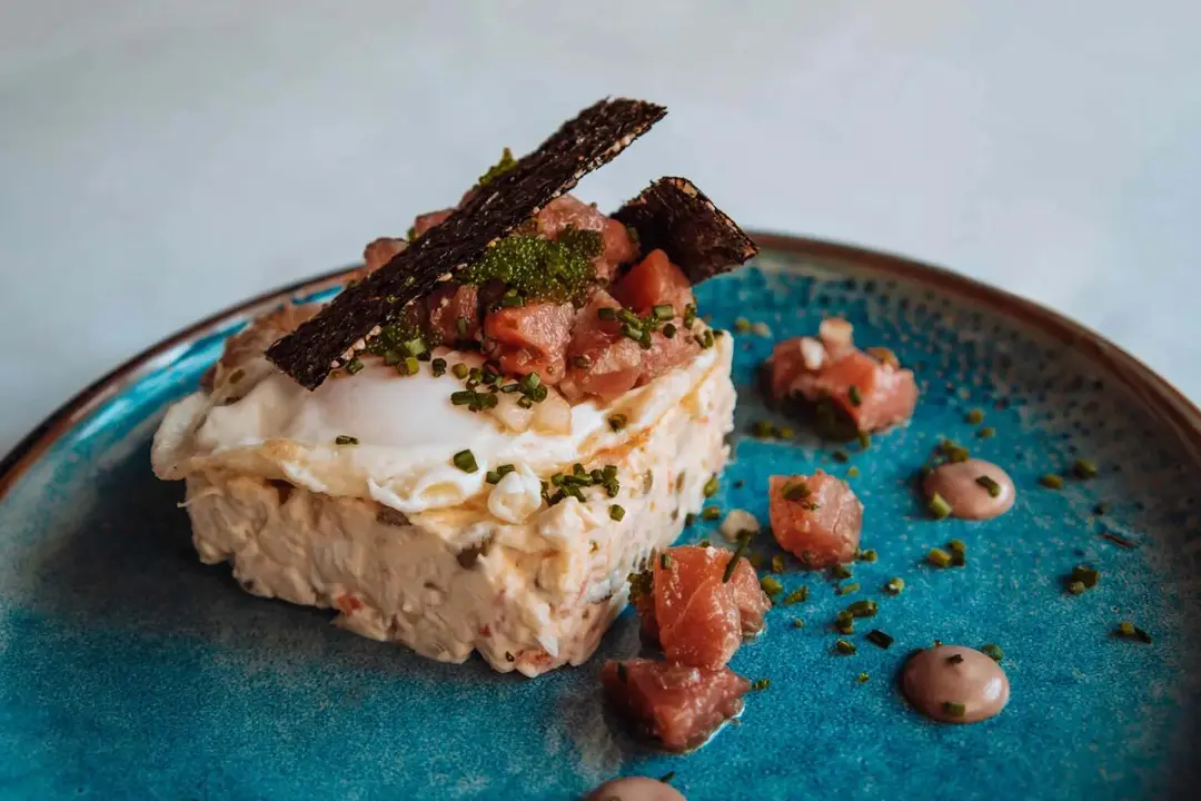 Ensaladilla disfrutona con tartar de at&uacute;n rojo, huevo frito y chips de alga. /El Disfrut&oacute;n