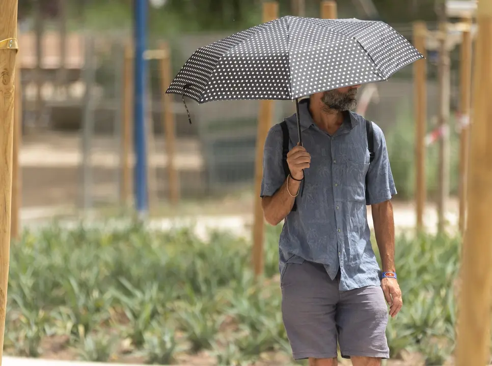 Un hombre pasea al sol con paraguas / E.P.