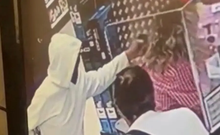 Imagen del atracador apuntando a la cabeza de la cajera durante el atraco /H.A.