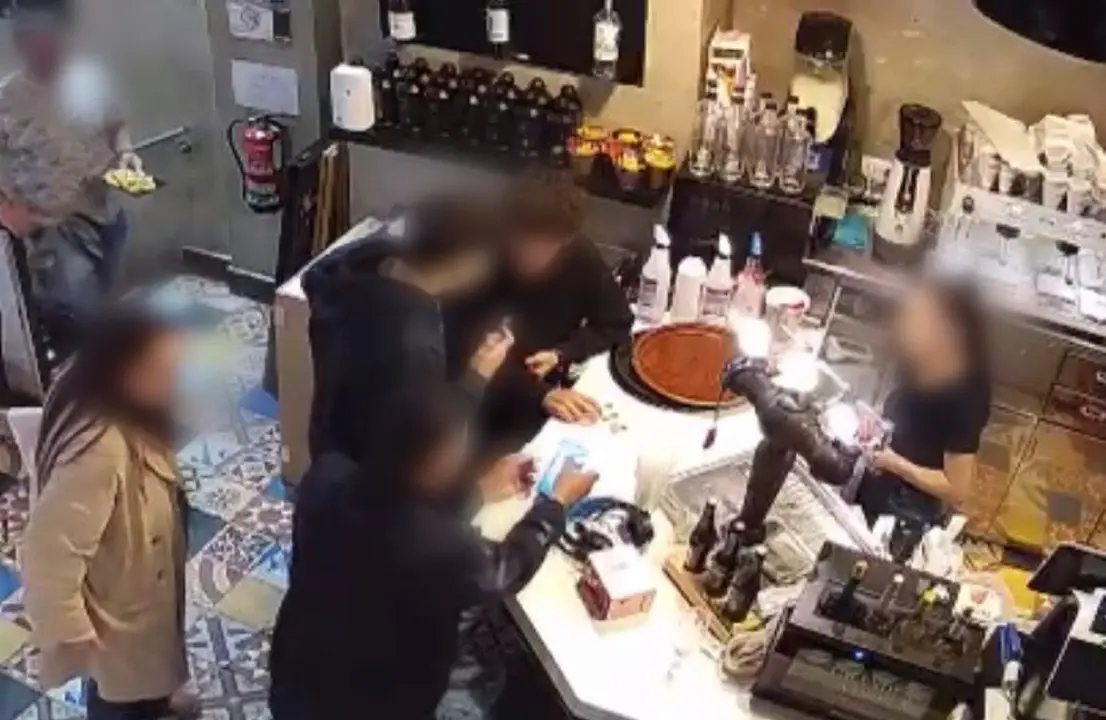 Imagen en la que se ve a una joven con gabardina que se hecha la mano a la espalda tras sentir el tocamiento /Cedidas a H.A.