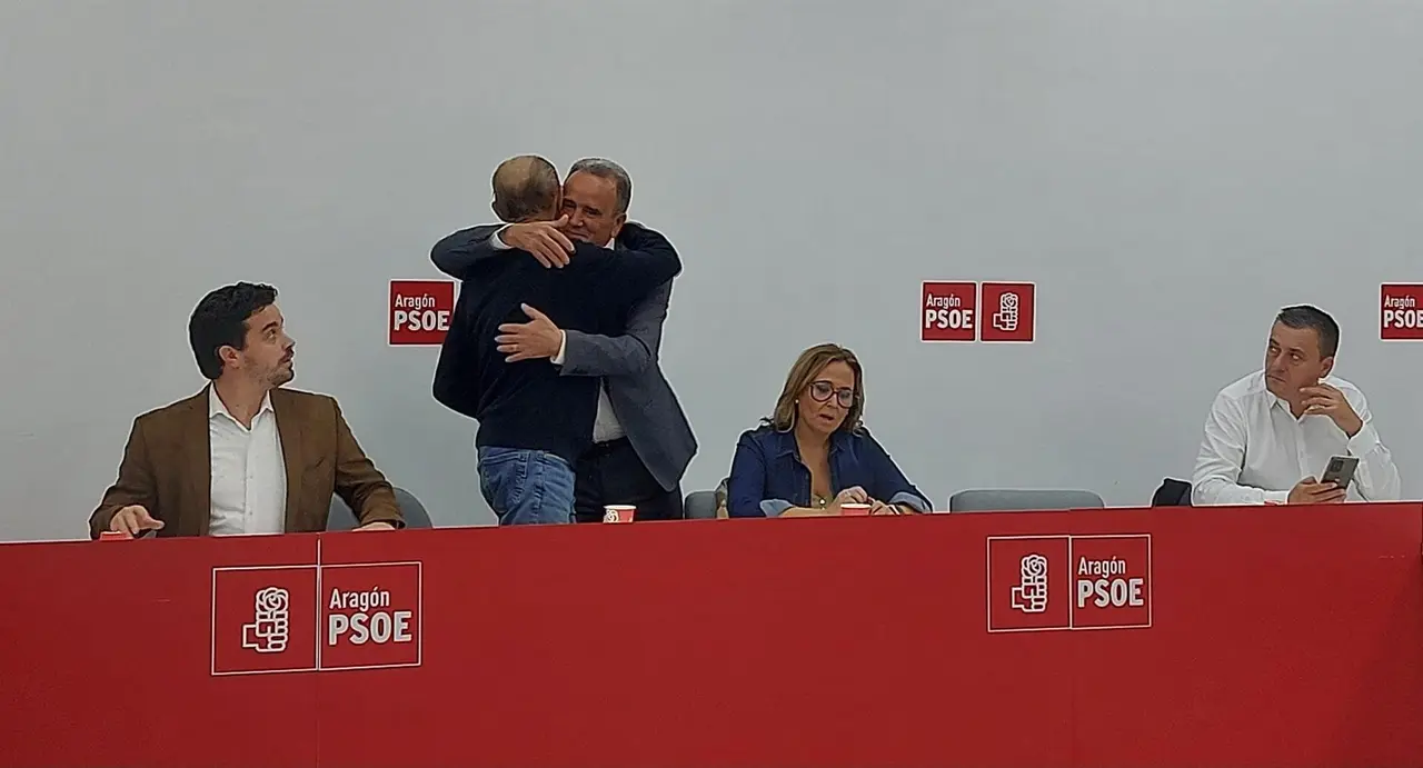 El secretario general del PSOE Arag&oacute;n, Javier Lamb&aacute;n, se abraza con el l&iacute;der del PSOE Zaragoza, Juan Antonio S&aacute;nchez Quero.