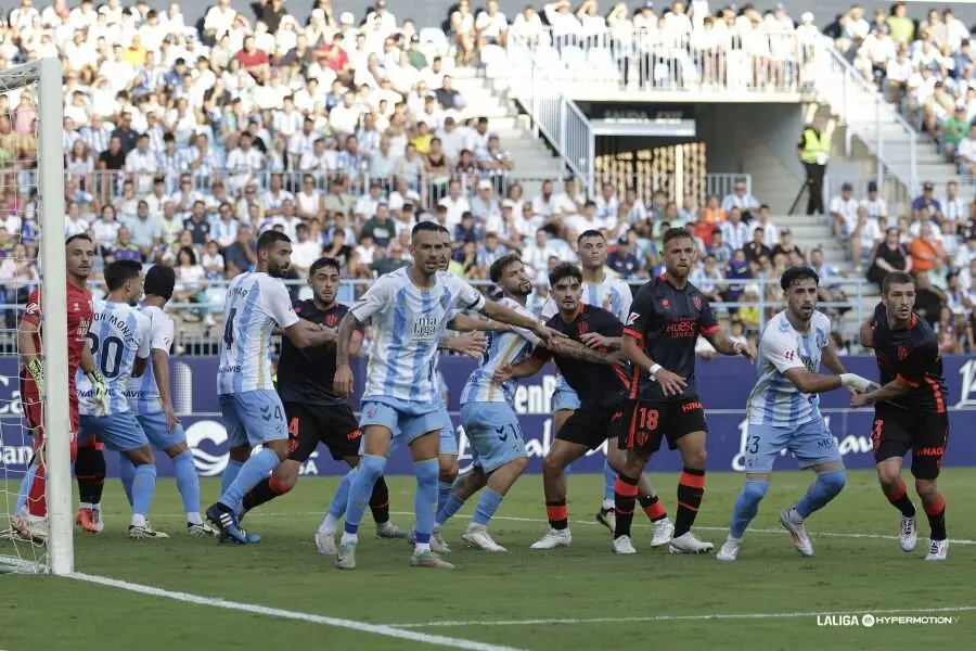 Jugadores de M&aacute;laga y SD Huesca durante el partido de ida / LaLiga