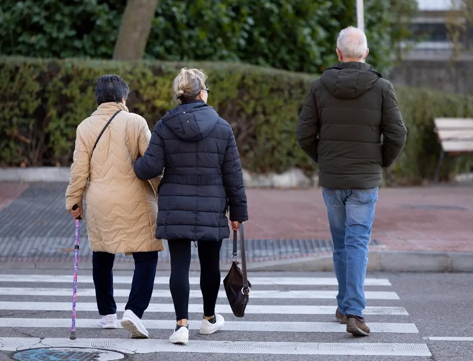 Varias personas mayores caminando por una calle/ EP