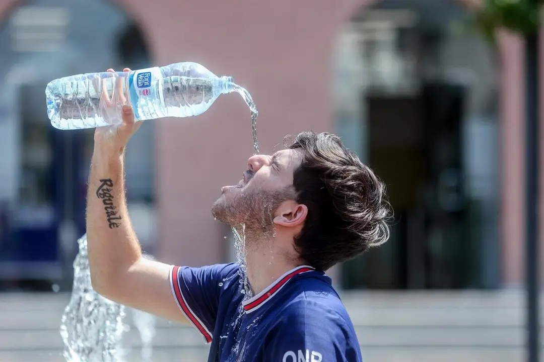 Imagen de archivo de un joven que se tira una botella de agua por encima para combatir el calor / Europa Press