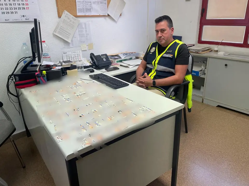 Imagen del Inspector Gonzalo de Miguel en su despacho con decenas de DNI's en su mesa recuperados en la &uacute;ltima operaci&oacute;n/H.A.