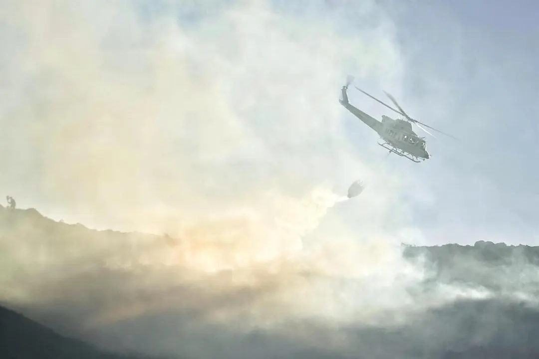Un helic&oacute;ptero de las Brigadas de Refuerzo en Incendios Forestales (BRIF) de Cantabria trabaja en las labores de extinci&oacute;n de un incendio forestal en el valle de Ardisana, a 10 de marzo de 2023, en Llano, Asutr