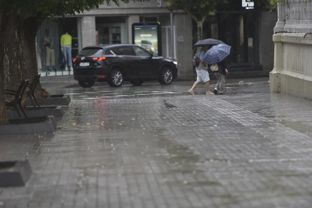 Dos personas caminan bajo la lluvia, en Huesca, Arag&oacute;n (Espa&ntilde;a). / EP