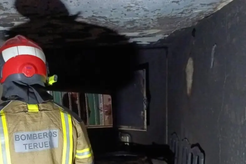 Un bombero de la DPT en el interior de la vivienda de Muniesa incendiada. / DPT
