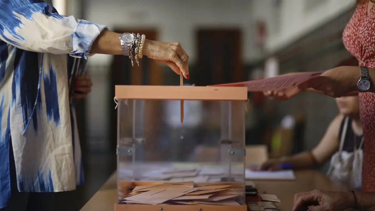 Una mujer introduce su voto en una urna