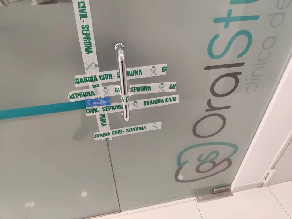 Una de las puertas de la cl&iacute;nica dental precintada por la Guardia Civil.
