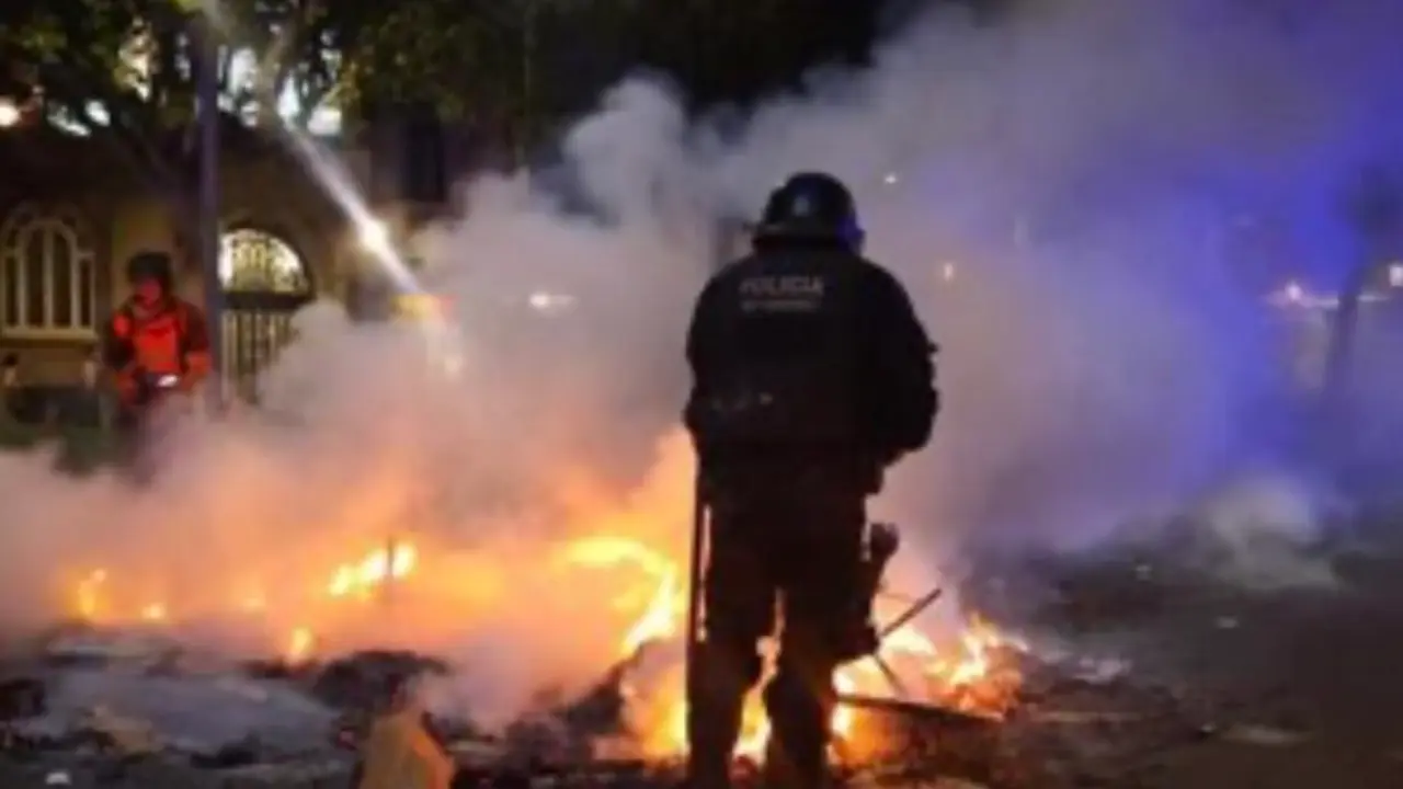 Imagen de un polic&iacute;a nacional aislado por el fuego durante las protestas en Barcelona /Europa Press