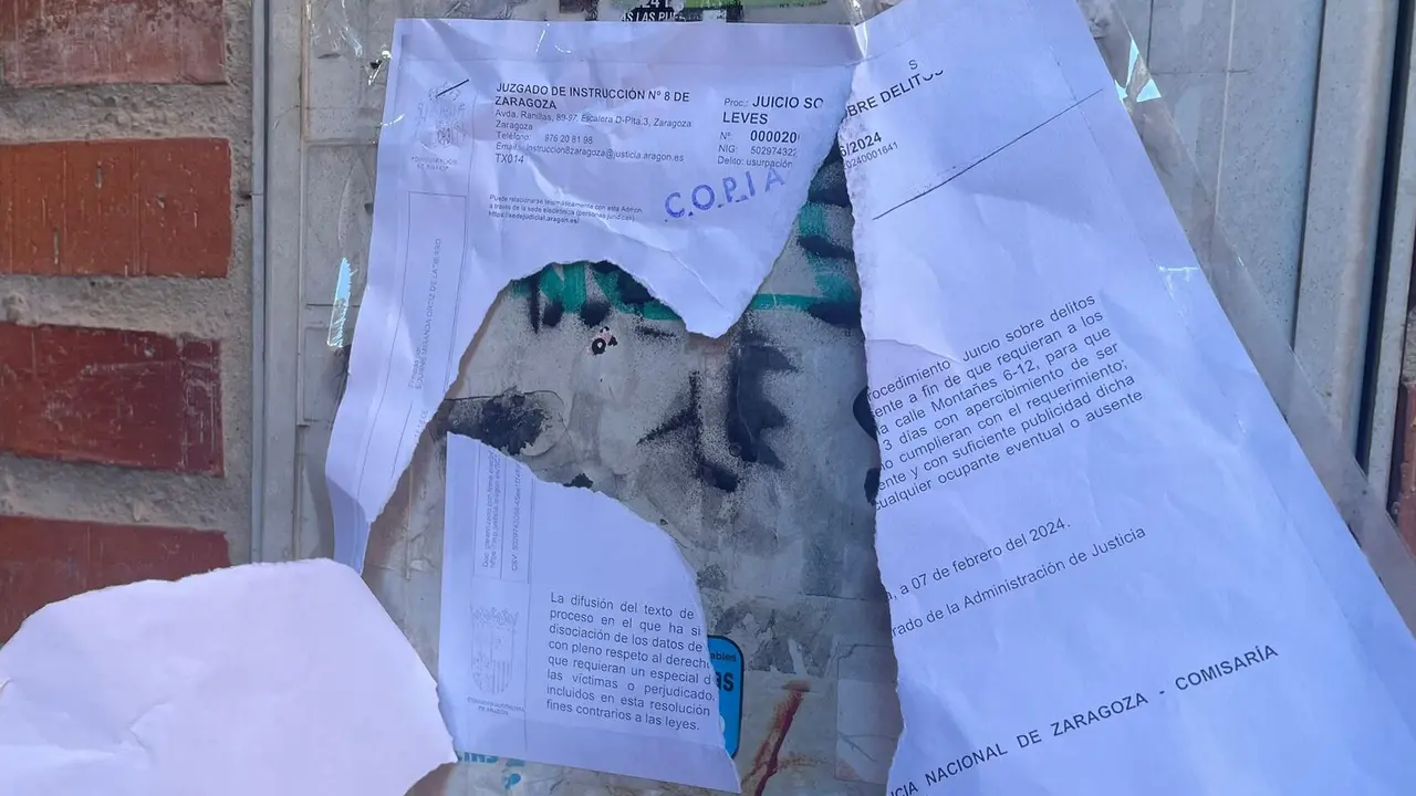 La orden del juzgado rota en la puerta del garaje de Delicias /H.A.