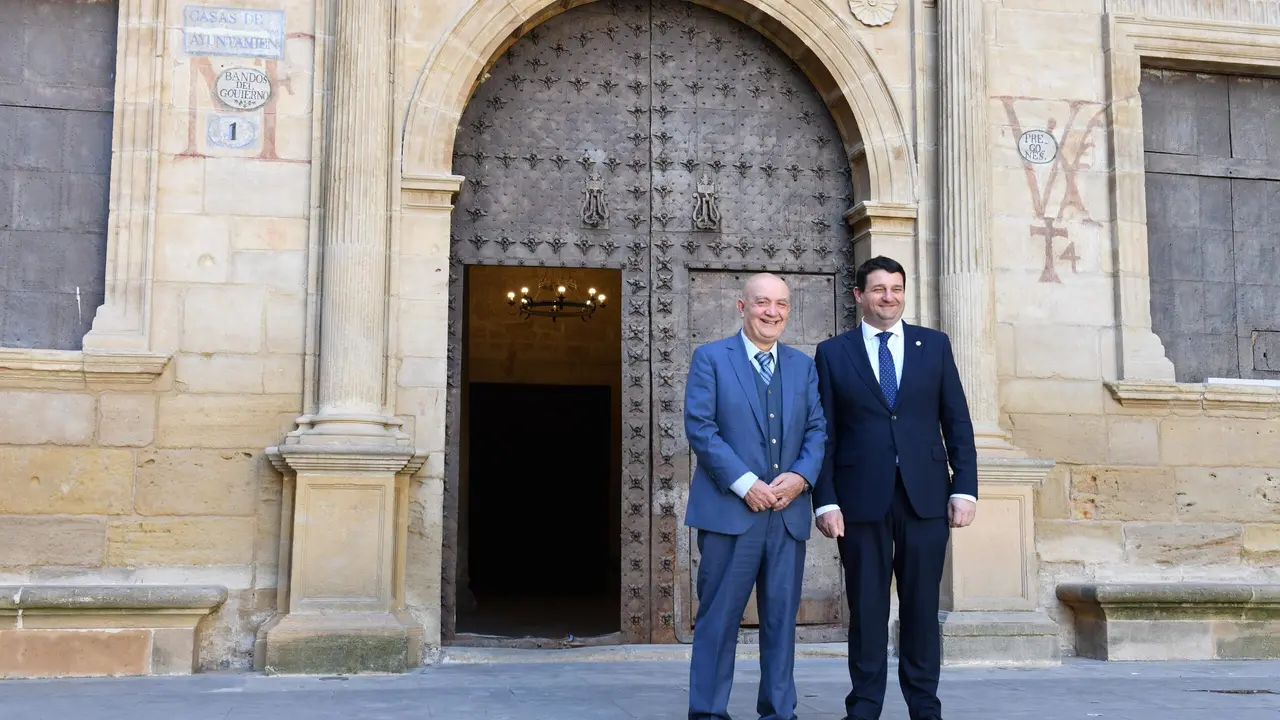 Jos&eacute; Mar&iacute;a Maestre (izqda.) y Miguel &Aacute;ngel Estevan (dcha.) junto a las pinturas de la fachada del Ayuntamiento de Alca&ntilde;iz