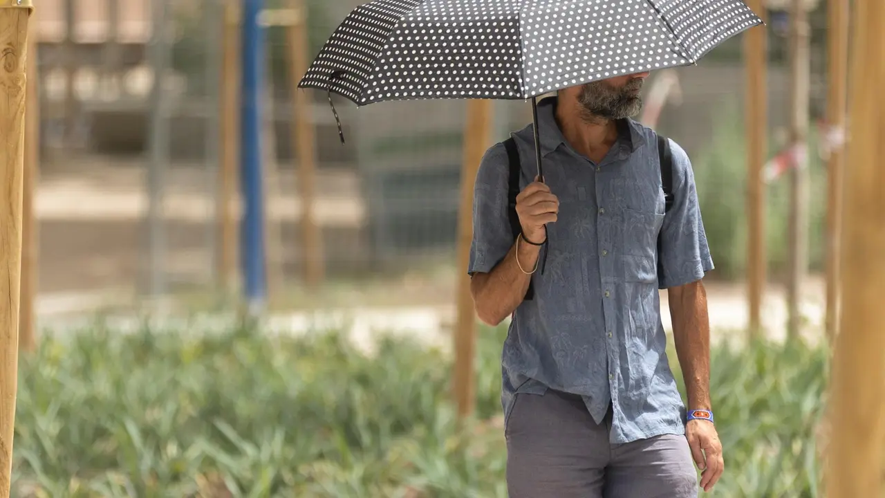 Un hombre pasea al sol con paraguas / E.P.