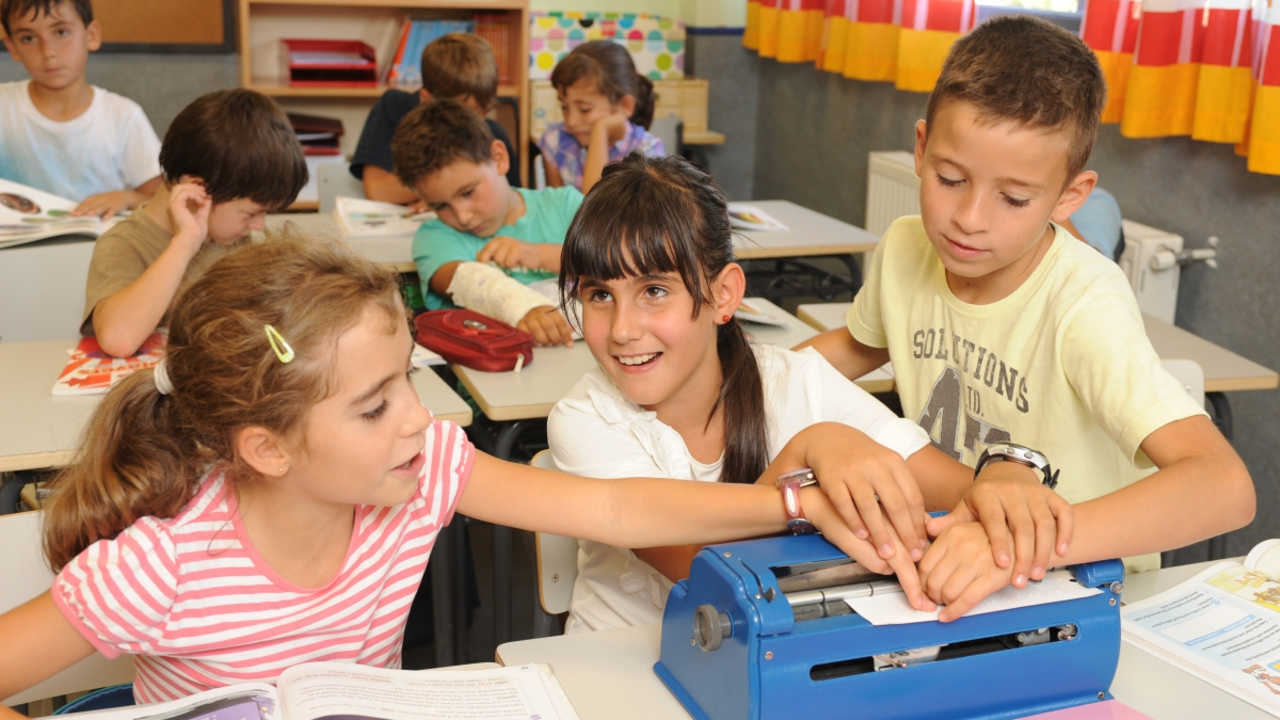 Estudiantes trabajando con una m&aacute;quina de escribir braille.