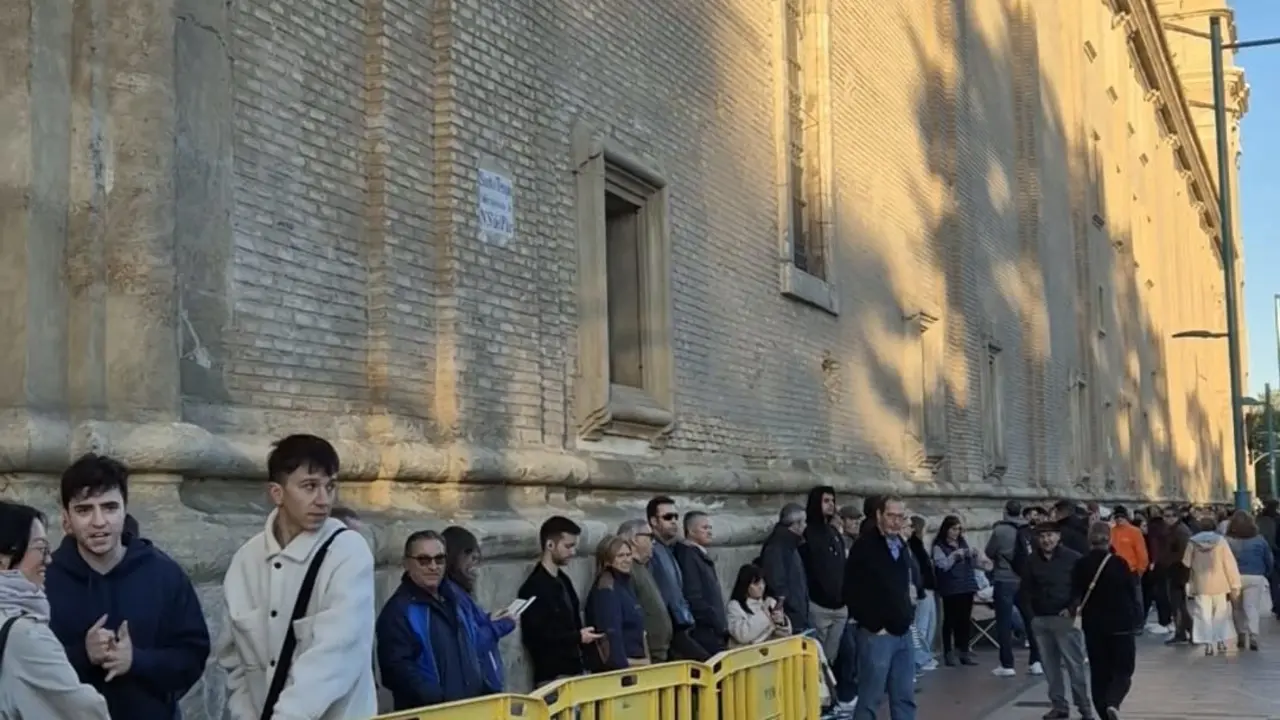 Larga fila para conseguir una cinta de la medida de la Virgen del Pilar edici&oacute;n cachirulo. / L. V.