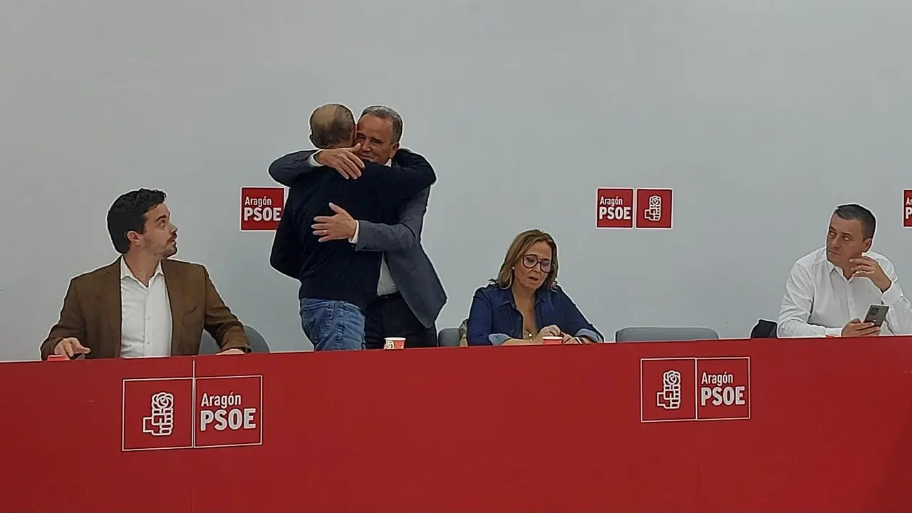 El secretario general del PSOE Arag&oacute;n, Javier Lamb&aacute;n, se abraza con el l&iacute;der del PSOE Zaragoza, Juan Antonio S&aacute;nchez Quero.