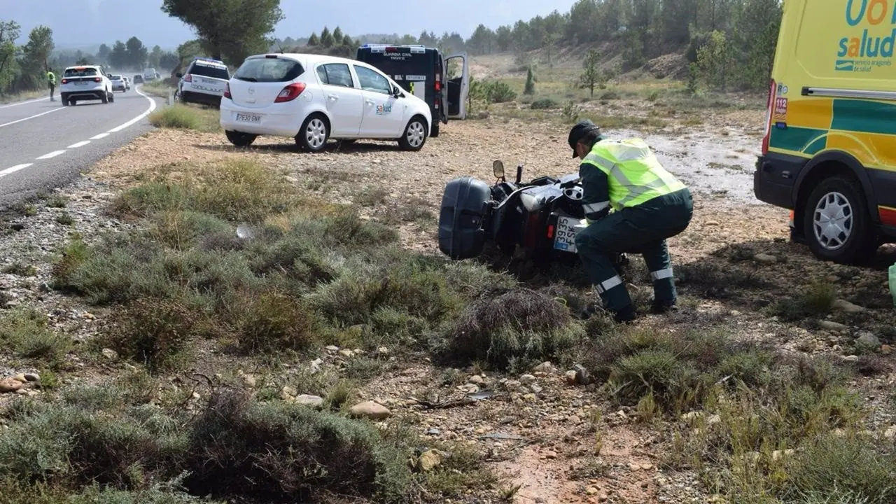 Un agente de la Guardia Civil examina la motocicleta con la que un motorista ha sufrido un acidente de tr&aacute;fico este domingo en la TEV-1611 en Loscos (Teruel) /  GUARDIA CIVIL TERUEL