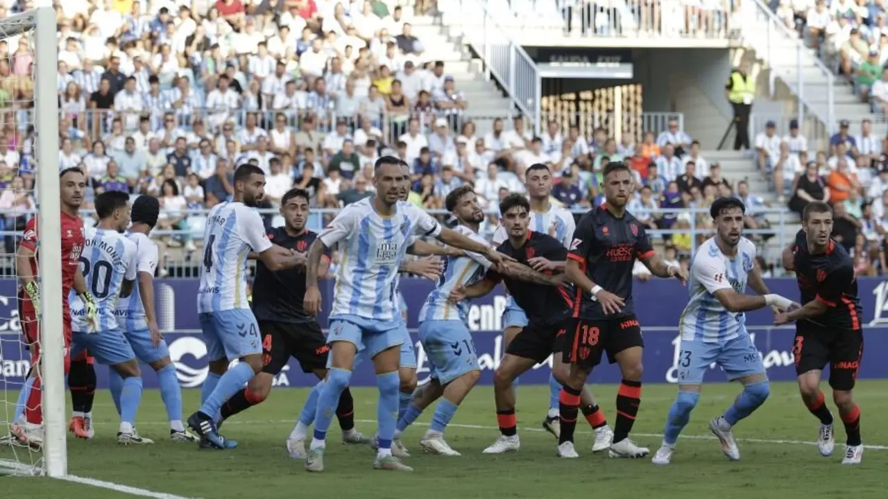 Jugadores de M&aacute;laga y SD Huesca durante el partido de ida / LaLiga