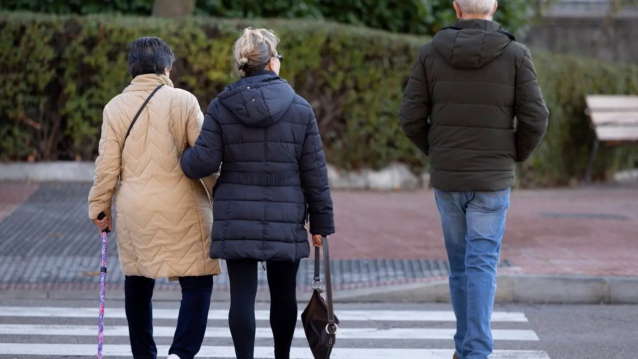 Varias personas mayores caminando por una calle/ EP