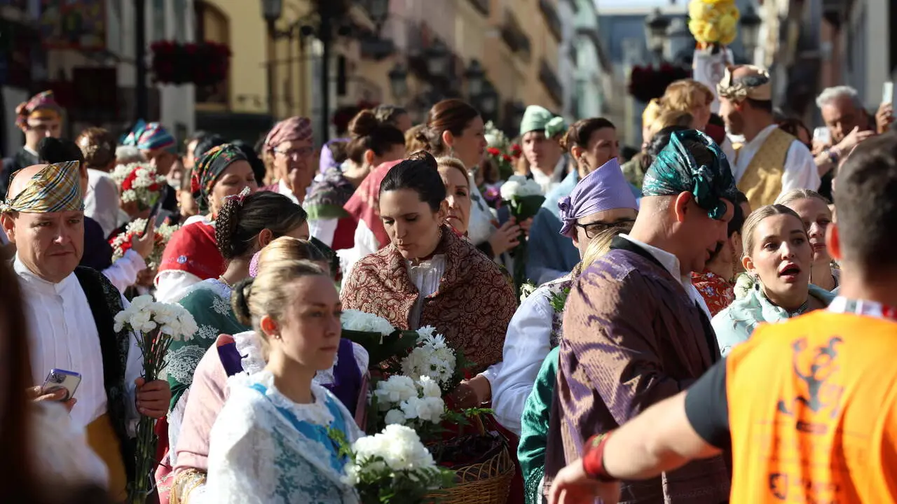 Imagen de los zaragozanos, con ramo en mano, yendo camino a dejar su ramo de flores a la Virgen del Pilar a primera hora de la ma&ntilde;ana. Fotograf&iacute;a: Fiestas del Pilar Oficial / Zaragoza Cultura.