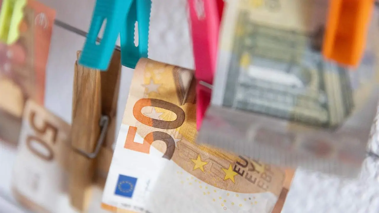 Varios billetes sujetos con pinzas. / EP
