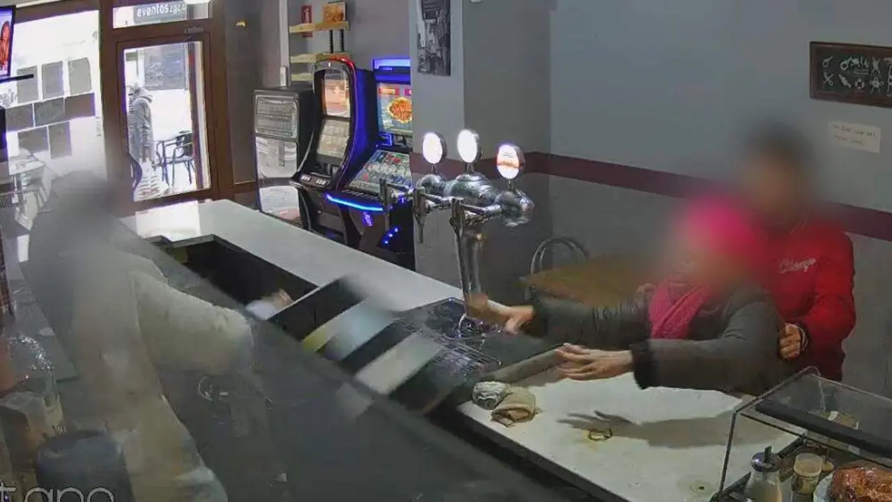 Imagen de la mujer acompa&ntilde;ada por su hijo lanzando objetos al interior de la barra/ Cedida a H.A.