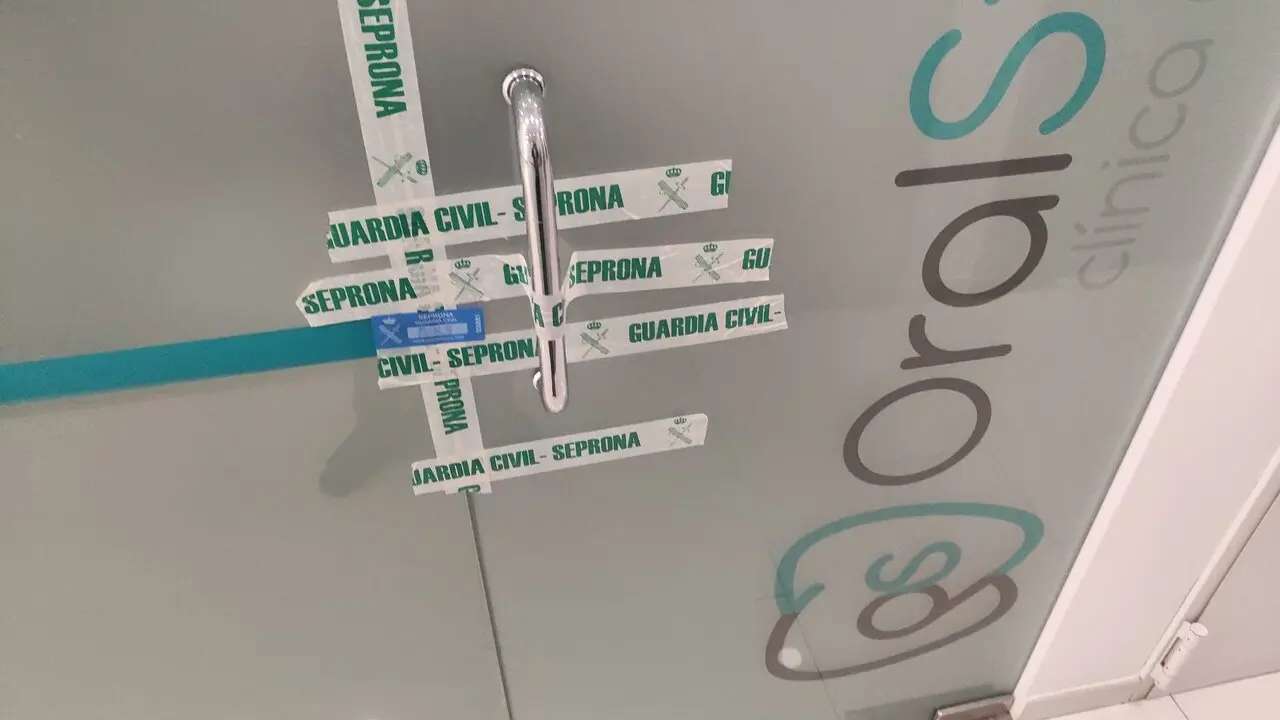 Una de las puertas de la cl&iacute;nica dental precintada por la Guardia Civil.