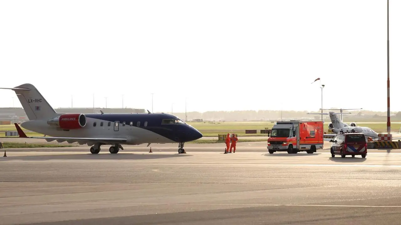 06 May 2026, Netherlands, Amsterdam: Medical staff in protective suits wait next to a German ambulance to receive the patients who have been evacuated from the hantavirus-hit cruise ship MV Hondius, after their arrival at Schiphol Airport in Amsterdam. Ph / EP
