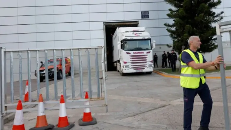 Un cami&oacute;n frigor&iacute;fico entra, rodeado de seguridad, a la morgue improvisada que ha sido instalada en la Feria de Valencia. Reuters
