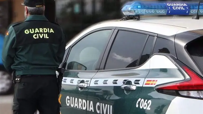 Un agente de la Guardia Civil junto a un veh&iacute;culo oficial, en una Imagen de archivo. / GUARDIA CIVIL