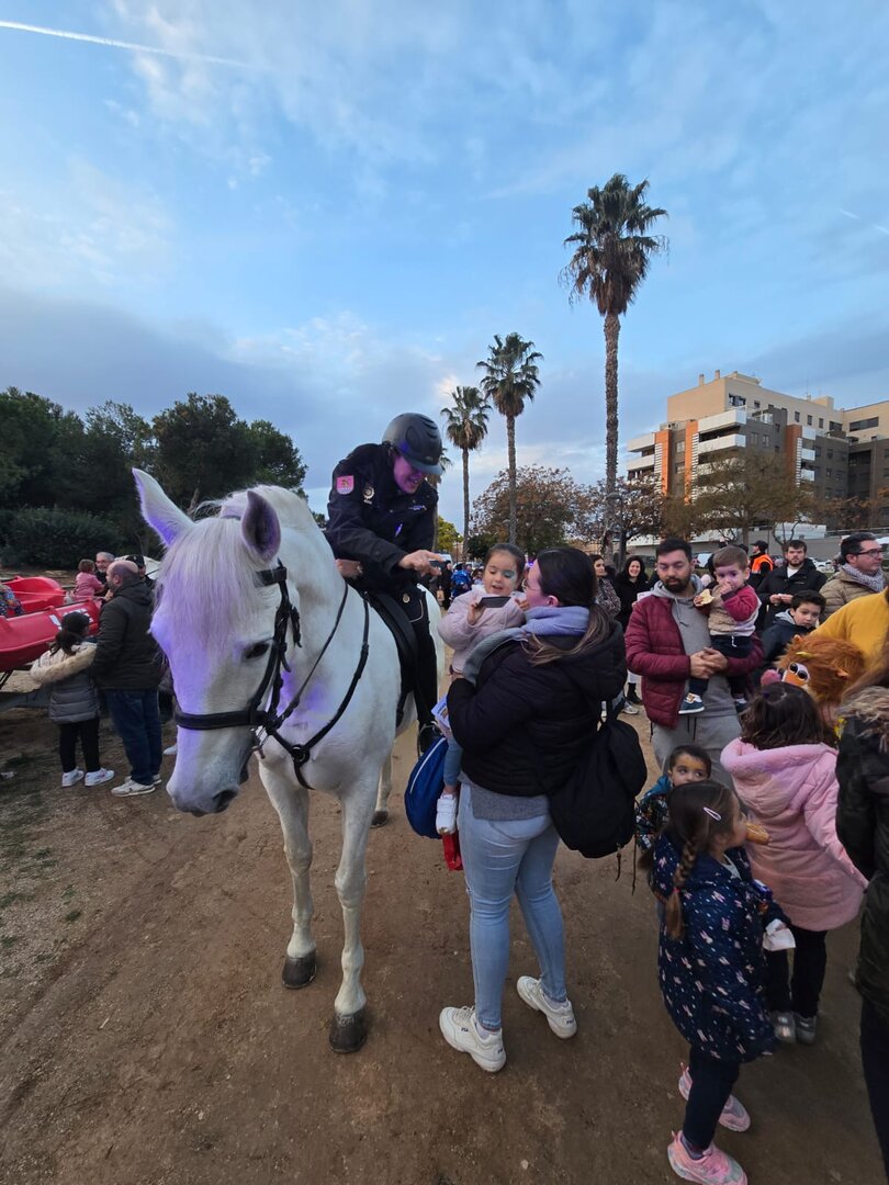 un policía a caballo entrega un regalo a uno de los niños /H.A.
