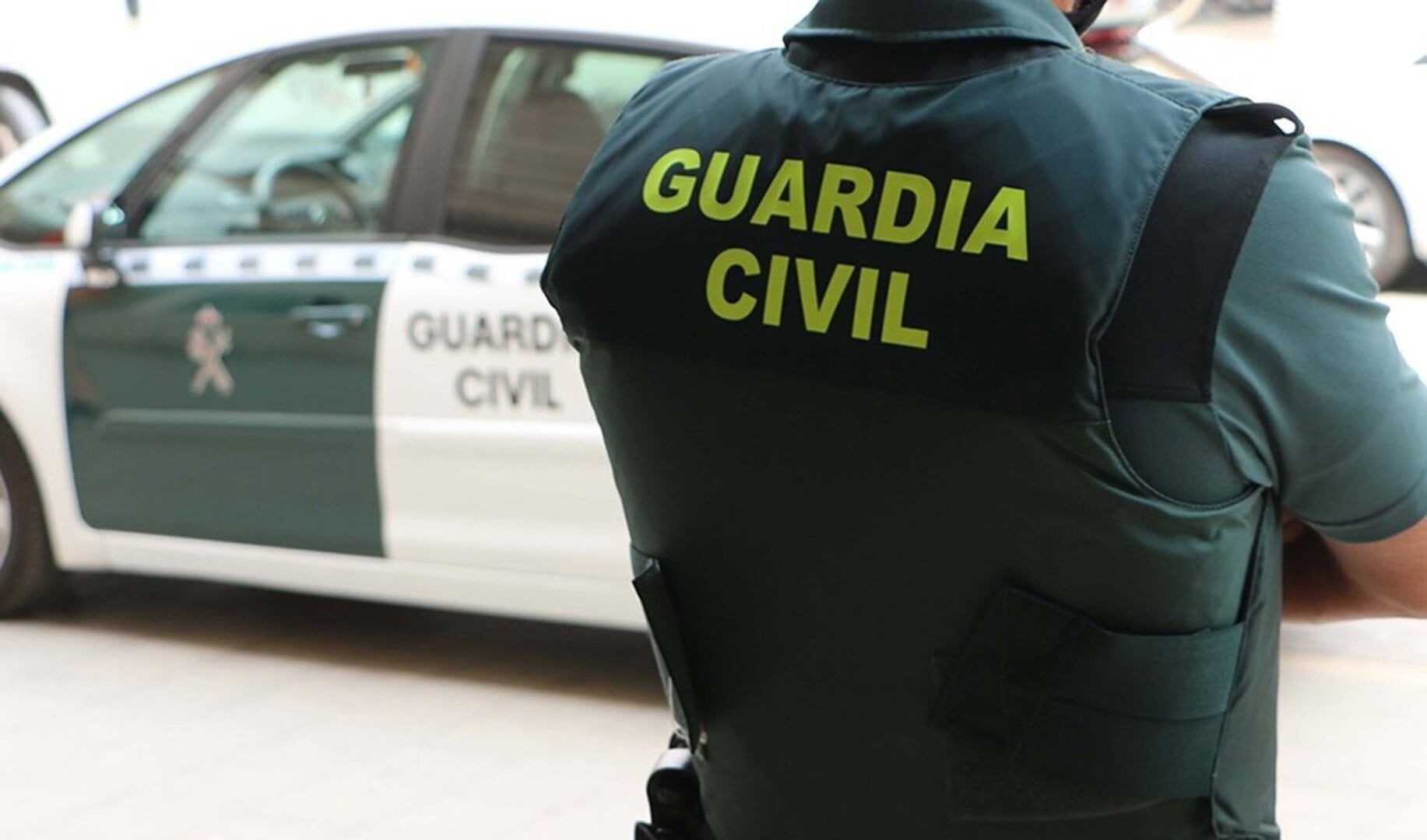 Un agente de la Guardia Civil, de espaldas, junto a un vehículo oficial. / GUARDIA CIVIL